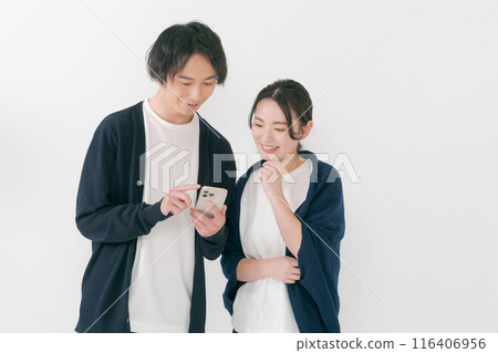 Smiling men and women looking at smartphones 116406956