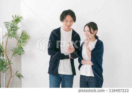 微笑的男人和女人看著智慧型手機 微笑的男人和女人看著智慧型手機 116407222