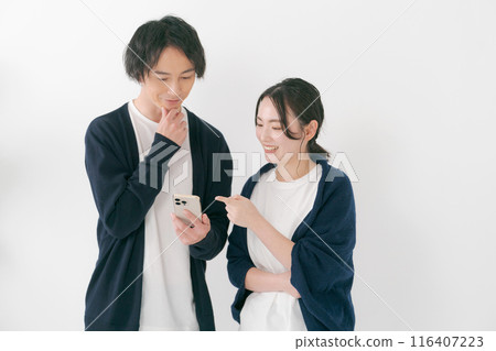 微笑的男人和女人看著智慧型手機 微笑的男人和女人看著智慧型手機 116407223