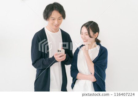 微笑的男人和女人看著智慧型手機 116407224