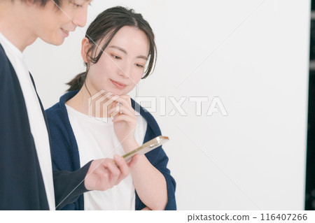 Smiling men and women looking at smartphones Smiling men and women looking at smartphones 116407266