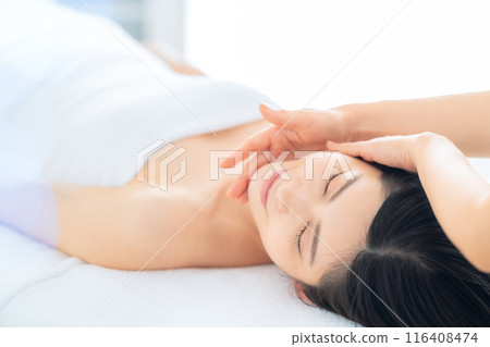 A middle-aged woman doing skin care at a beauty salon 116408474