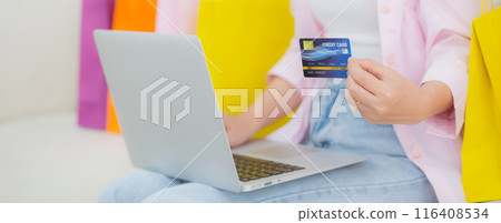 Young asian woman sitting on sofa using laptop computer shopping online with credit card. Young asian woman sitting on sofa using laptop computer shopping online with credit card. 116408534
