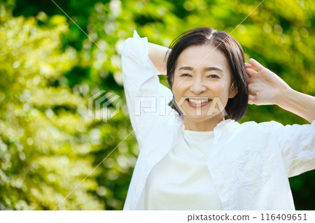 Portrait of a middle-aged woman stretching in the sunlight Portrait of a middle-aged woman stretching in the sunlight 116409651