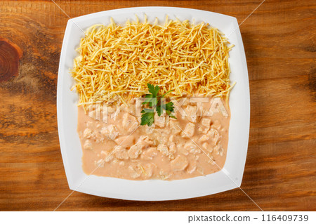 homemade chicken stroganoff in ceramic dish isolated on wooden table 116409739