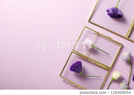 Fresh flowers and glass frames on purple background, space for text 116409950