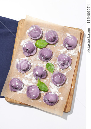 Purple dumplings in kitchen board and towel on white background, top view Purple dumplings in kitchen board and towel on white background, top view 116409974