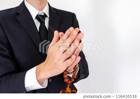 一個男人手裡拿著念珠,雙手合十 一個男人手裡拿著念珠,雙手合十 116410538