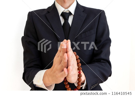 一個男人手裡拿著念珠,雙手合十 一個男人手裡拿著念珠,雙手合十 116410545