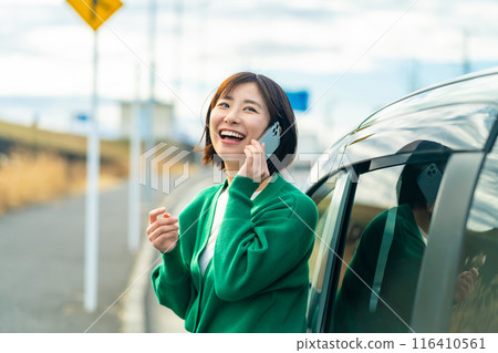 A woman calling in front of her car. A woman calling about car trouble. 116410561