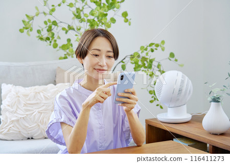一個女人在客廳裡使用智能手機 116411273