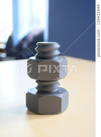 Object in form of washer and bolt of gray color printed on 3D printer. Three-dimensional model printed on 3D printer from molten plastic of red color. Concept 3D Printing. FDM 3D Printing technology Object in form of washer and bolt of gray color printed on 3D printer. Three-dimensional model printed on 3D printer from molten plastic of red color. Concept 3D Printing. FDM 3D Printing technology 116412844