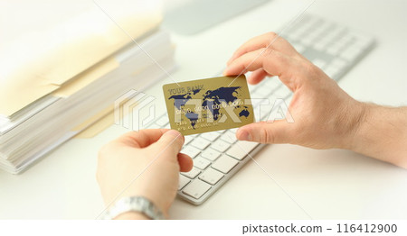 Male hand hold plastic bank card aganist 116412900