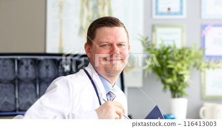 Male doctor in office looking in camera smiling Male doctor in office looking in camera smiling 116413003