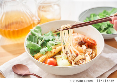 A hearty spicy soup made with glass noodles and topped with shrimp and other ingredients. 116413236