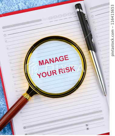 Manage your Risks symbol. Concept words Manage your Risks viewed through a magnifying glass in a business notebook Manage your Risks symbol. Concept words Manage your Risks viewed through a magnifying glass in a business notebook 116413653