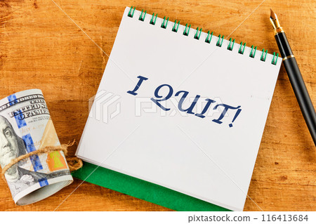 I Quit word on a blank sheet of notepad against a papyrus background 116413684