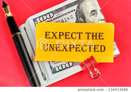 Expect The Unexpected word on a yellow piece of paper on dollars on a red background 116413686