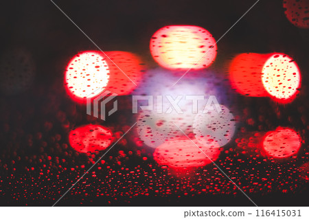 Glowing red lights against wet glass window 116415031