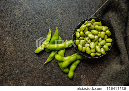 Green edamame pods. Fresh soybeans in bowl on black table. Top view. 116415586