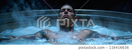 man floats peacefully in a tub of water, his body weightless and serene in the tranquil blue surroundings. 116416636