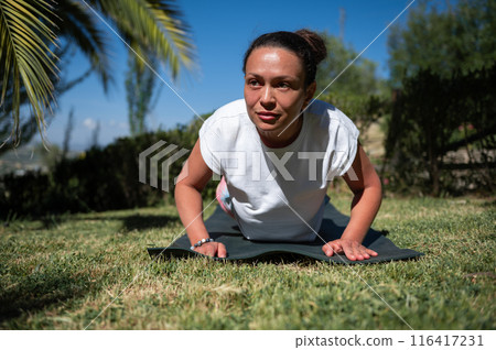Woman practicing outdoor yoga in a sunny garden, focusing on fitness and wellness Woman practicing outdoor yoga in a sunny garden, focusing on fitness and wellness 116417231