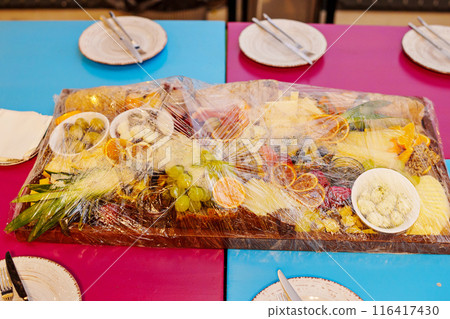 A large fruit platter with exotic berries and fruits under the film. A large fruit platter with exotic berries and fruits under the film. 116417430