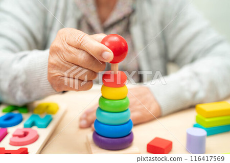 Alzheimer disease AD, Asian senior woman patient suffering from dementia learn practical motor skills rehabilitation. 116417569