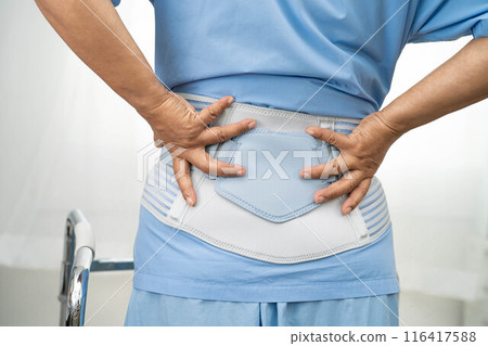 Asian woman patient wearing back pain support belt for orthopedic lumbar with walker. Asian woman patient wearing back pain support belt for orthopedic lumbar with walker. 116417588