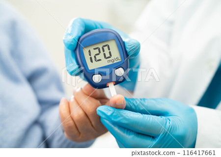Doctor use digital glucose monitor measure and test stripe for check diabetes from finger blood sugar level. 116417661