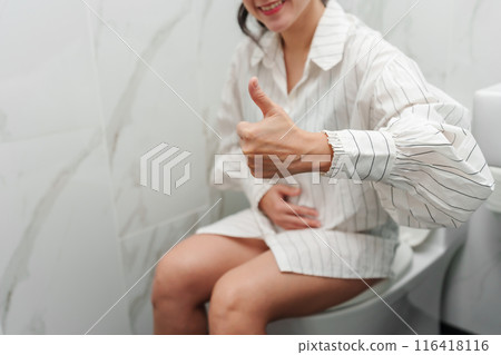 happy woman giving a thumbs up from a toilet bowl in bathroom happy woman giving a thumbs up from a toilet bowl in bathroom 116418116