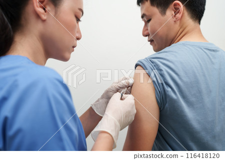 doctor holding syringe and making injection vaccine to patient doctor holding syringe and making injection vaccine to patient 116418120