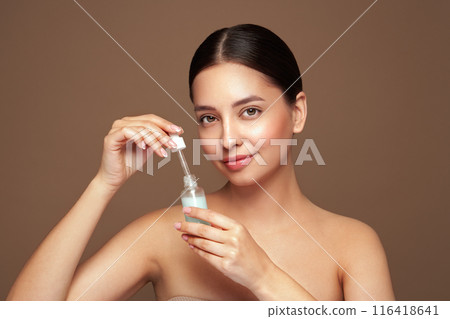 Woman holding a cosmetic jar of oil serum 116418641