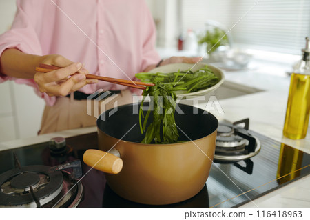 Woman Boiling Greens In Pan 116418963
