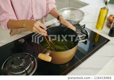 Woman Boiling Greens For Korean Dish Woman Boiling Greens For Korean Dish 116418968