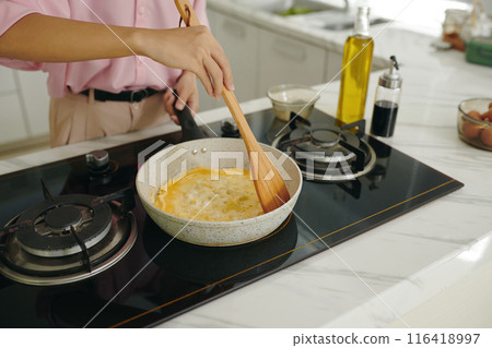 Woman Making Omelet On Pan For Breakfast Woman Making Omelet On Pan For Breakfast 116418997