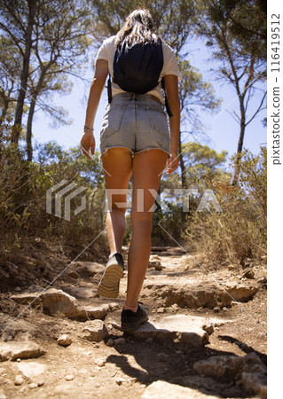 Young woman walk along the hiking trail in the forest during sumer 116419512