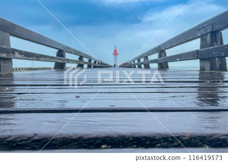 Wooden pier with red lighthouse on blue sky background in the Normandia, France. Shallow depth of field 116419573
