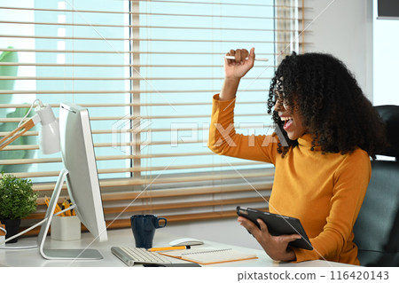 Happy African American woman getting good news celebrating her success at workplace Happy African American woman getting good news celebrating her success at workplace 116420143