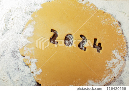 2024 numbers cut from rolled raw cookie dough on flour table 116420666