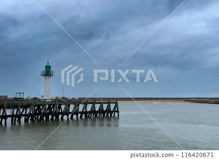 Lighthouse at the end of the pier on a stormy day in Normandy, France in a cloudy day. 116420671