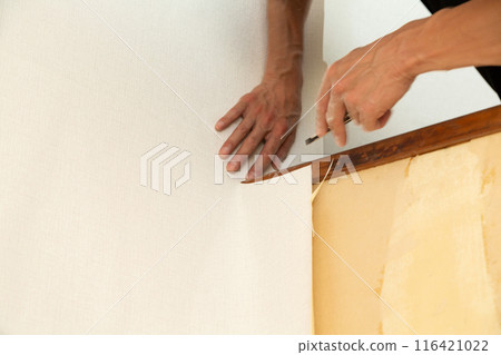 A craftsman applying wallpaper to a used house 116421022