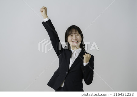 Portrait of a young woman posing cheerfully in a suit against a white background Portrait of a young woman posing cheerfully in a suit against a white background 116421228