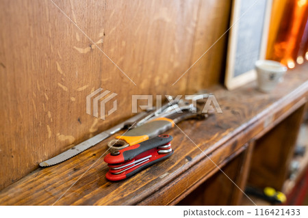 An assortment of tools on a wooden shelf in a wellorganized workshop An assortment of tools on a wooden shelf in a wellorganized workshop 116421433