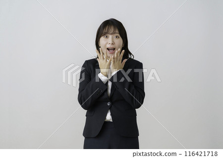 Portrait of a young woman in a suit with a surprised face against a white background Portrait of a young woman in a suit with a surprised face against a white background 116421718
