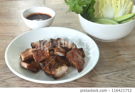 gilled slice pork bone on plate with vegetable dipping spicy chili tamarind sauce gilled slice pork bone on plate with vegetable dipping spicy chili tamarind sauce 116421752