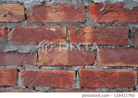 Brick wall, background, cement drips. Backdrop with red brick hand kneaded and moulded. Close-up, detail and texture. Uneven masonry, not neat work, untidy construction. Brick wall, background, cement drips. Backdrop with red brick hand kneaded and moulded. Close-up, detail and texture. Uneven masonry, not neat work, untidy construction. 116421760