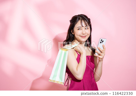 一位年輕女子用智慧型手機購物 116422330