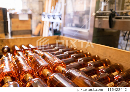 The Wooden Crate holds rows of Rose Wine Bottles arranged at a Distillery The Wooden Crate holds rows of Rose Wine Bottles arranged at a Distillery 116422442