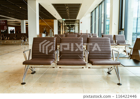 Airport lounge with comfy chairs, windows for travelers to relax before flying Airport lounge with comfy chairs, windows for travelers to relax before flying 116422446